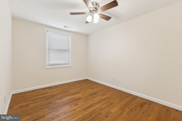 an empty room with a window and a ceiling fan