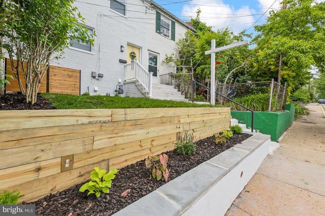 a front view of a house with a yard and potted plants