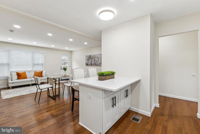 a kitchen with a wooden floor and white cabinets
