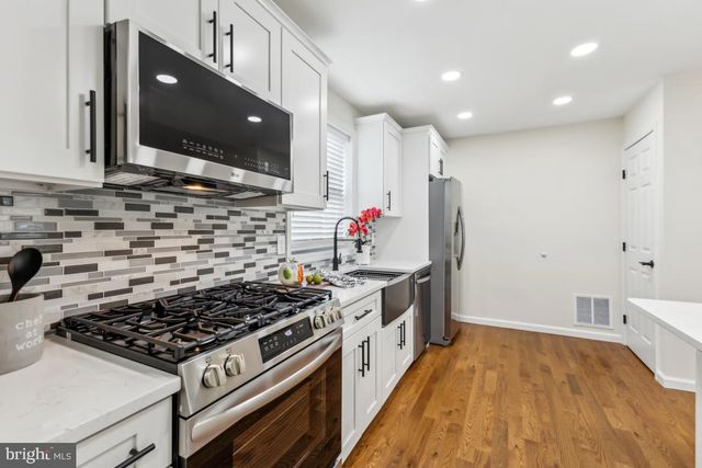 a kitchen with stainless steel appliances a sink stove and cabinets