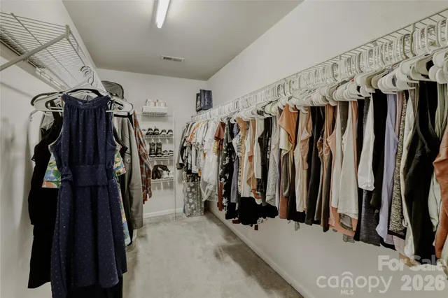 a view of walk in closet with clothes and shoes