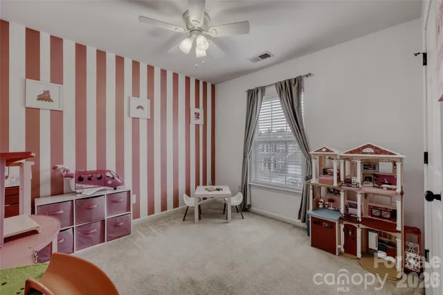 a living room with furniture a bookshelf and a window