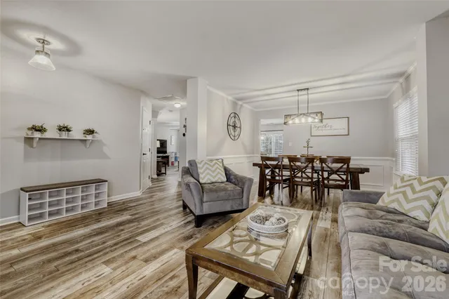 a living room with furniture a dining table and chairs with wooden floor