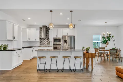 a kitchen with granite countertop a sink a stove and a microwave