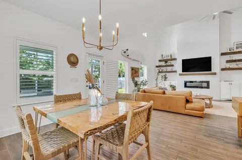 a view of a dining room and livingroom with furniture wooden floor a chandelier