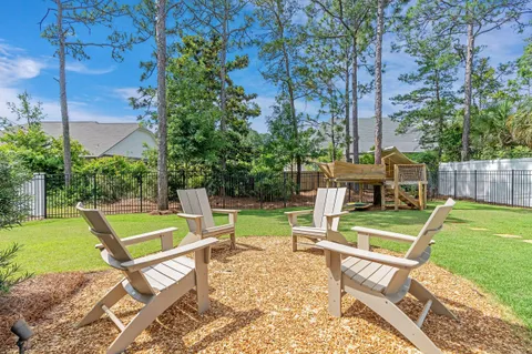 a view of a chair and table in backyard of the house