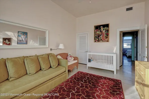 a living room with furniture and a baby crib