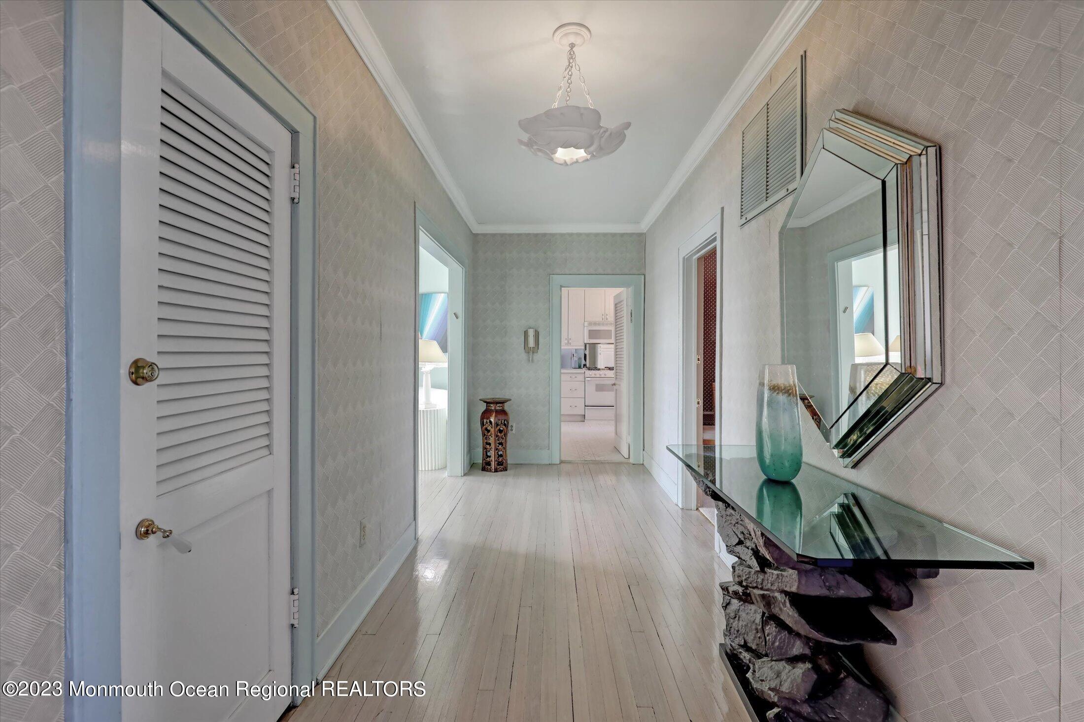 1 Roseld Avenue, Unit A3 Deal, NJ 07723 - Photo 4 of 35 a hallway with wooden floor a chandelier