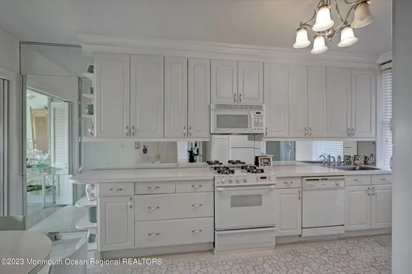a kitchen with cabinets appliances a sink and a counter top space