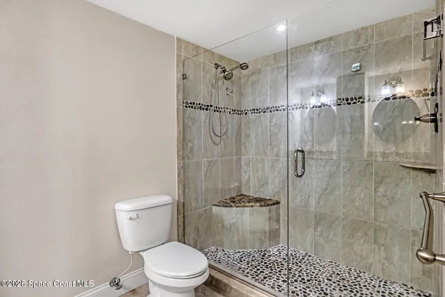 a bathroom with a granite countertop sink a toilet and mirror