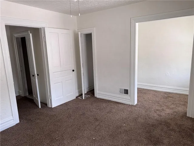 an empty room with a ceiling fan and carpet