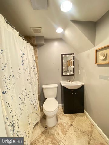 a bathroom with a toilet sink and shower curtain