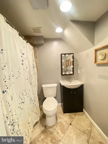 a bathroom with a toilet sink and shower curtain