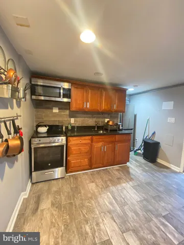 a large kitchen with stainless steel appliances wooden cabinets and a counter top space