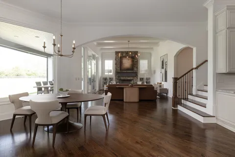 a view of a hallway with wooden floor and stairs