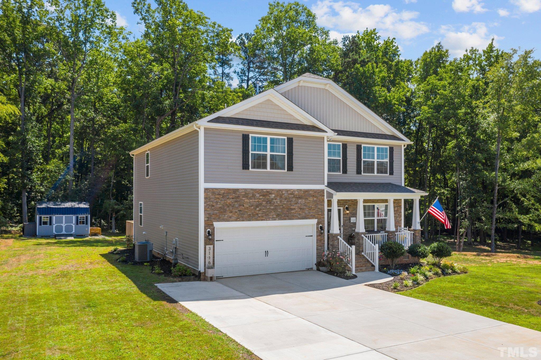 a front view of house with yard and trees in the background