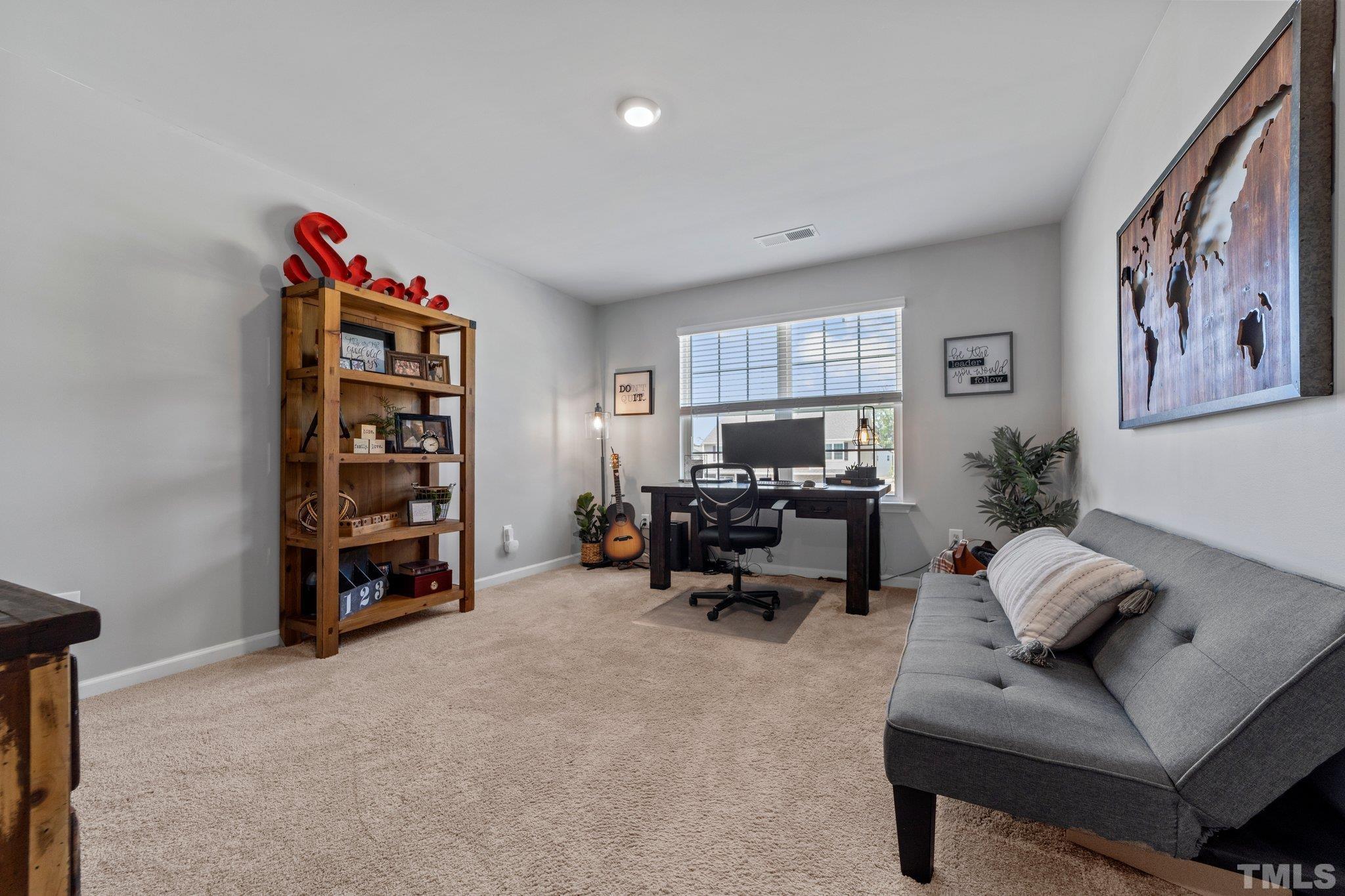 3116 Longpine Road Burlington, NC 27215 - Photo 23 of 29 a living room with furniture a couch and a bookshelf