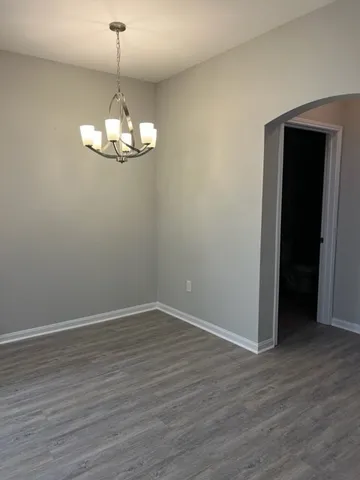 a view of a room with wooden floor and chandelier
