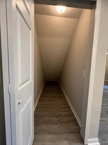a view of a hallway with wooden floor and staircase