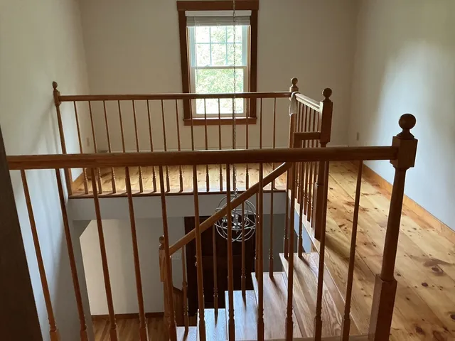a view of staircase with railing and a window