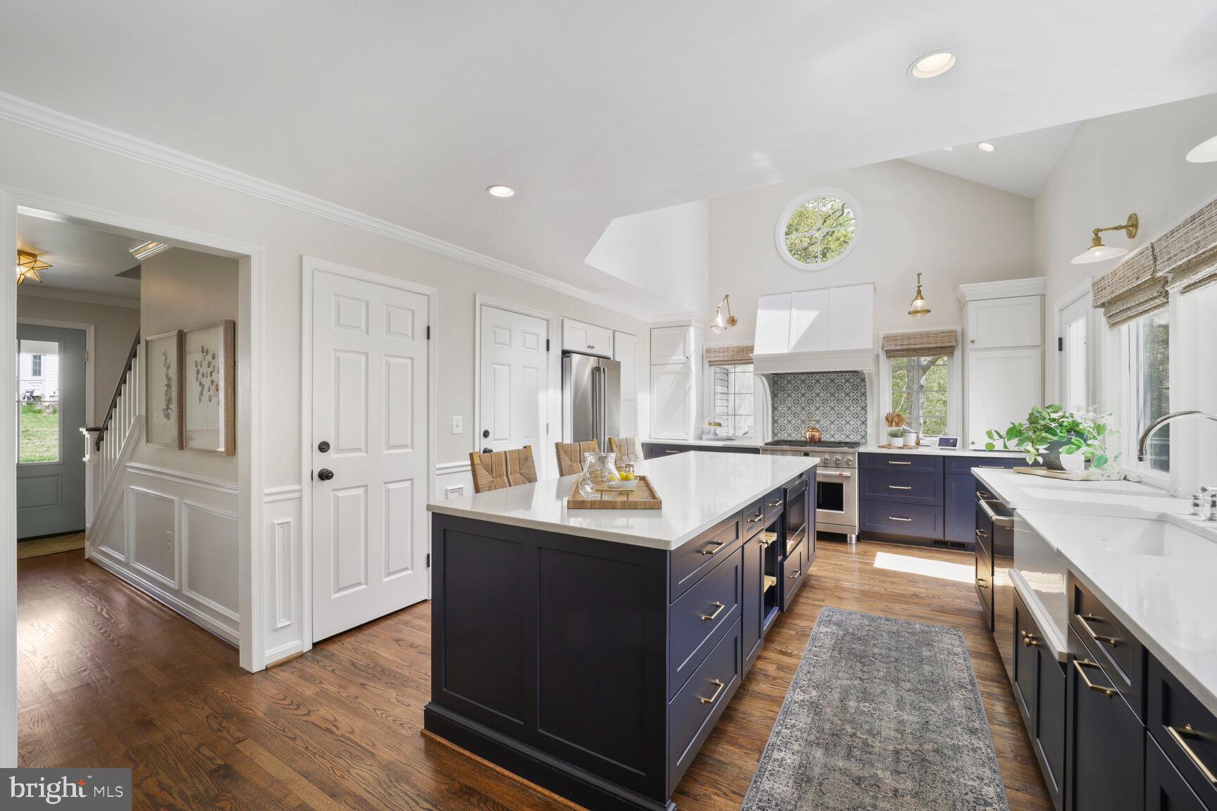 a large kitchen with stainless steel appliances lots of counter space and wooden floor