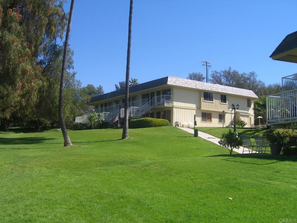 a view of a house with a big yard and potted plants