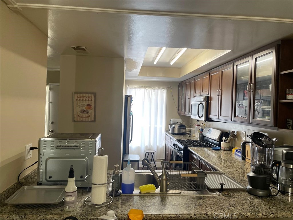 404 Brighton Springs Costa Mesa, CA 92627 - Photo 7 of 22 a kitchen with sink refrigerator and stove top oven