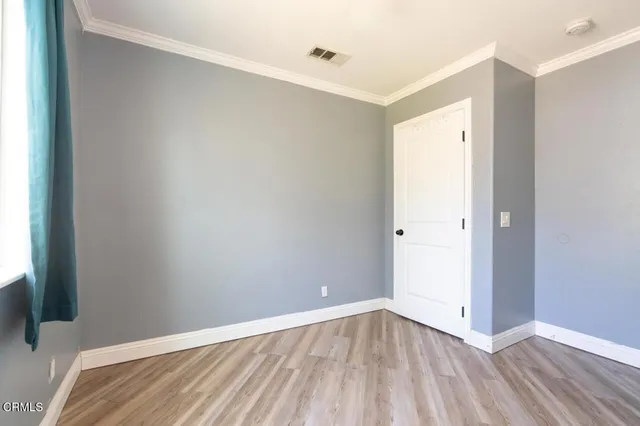 a view of an empty room with wooden floor
