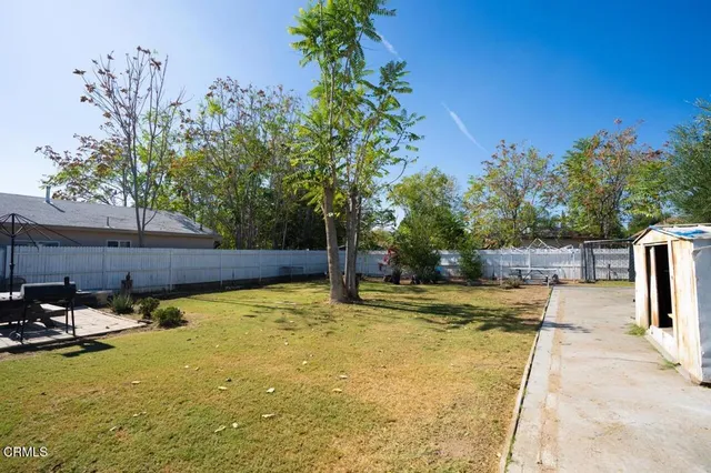 a swimming pool with some potted plants and large trees