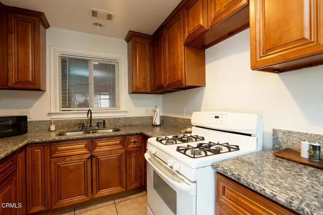 a kitchen with a sink stove top oven and cabinets