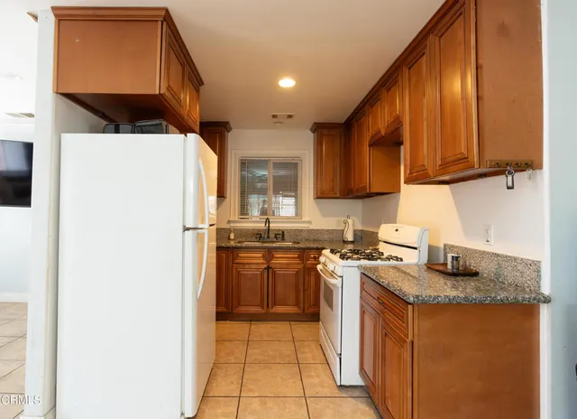 a kitchen with stainless steel appliances granite countertop a stove a refrigerator and a sink