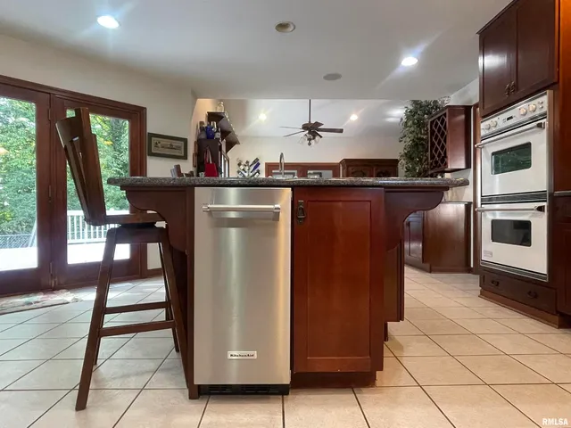 a kitchen with stainless steel appliances granite countertop a stove a sink a microwave and a refrigerator