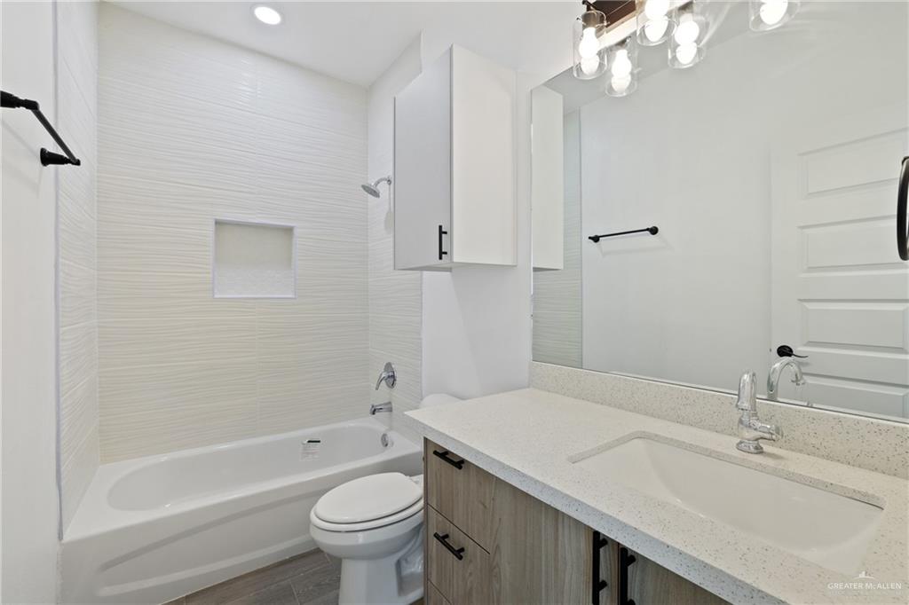 3208 Briggs Street, Unit 3 Weslaco, TX 78596 - Photo 9 of 10 Bathroom featuring shower / bathtub combination, vanity, toilet, and wood finished floors