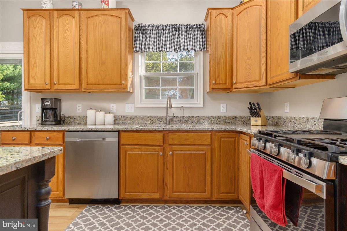20376 Splendor View Terrace Hagerstown, MD 21740 - Photo 11 of 52 a kitchen with stainless steel appliances granite countertop a stove a sink dishwasher and cabinets with wooden floor