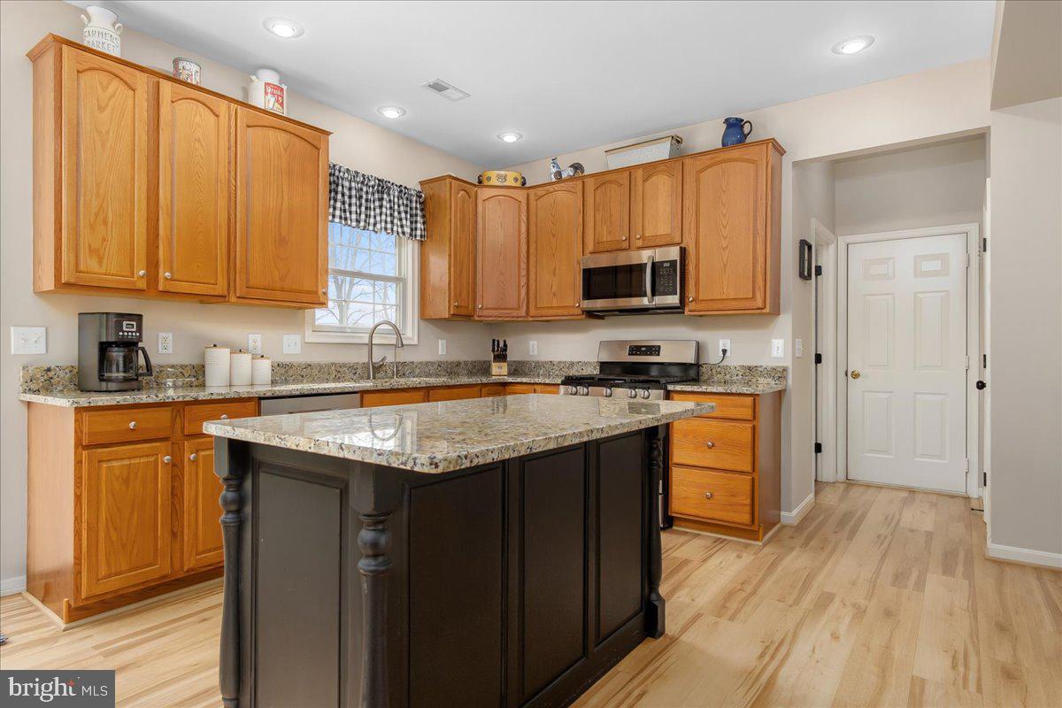 20376 Splendor View Terrace Hagerstown, MD 21740 - Photo 9 of 52 a kitchen with stainless steel appliances granite countertop a stove a sink dishwasher and a refrigerator with wooden floor
