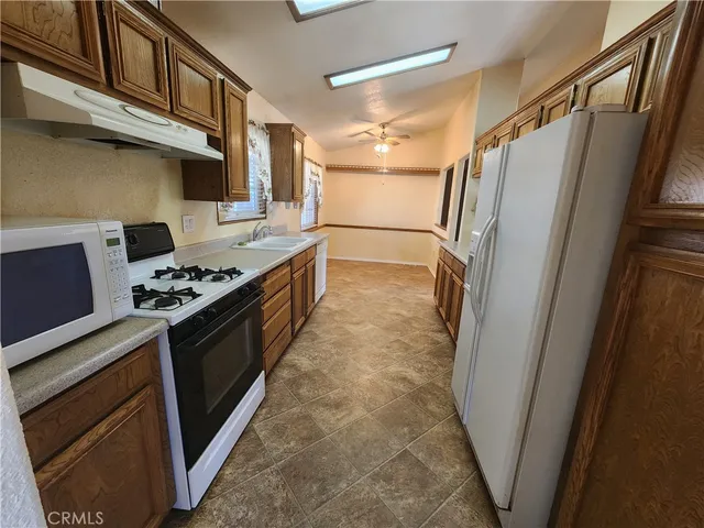 a kitchen with stainless steel appliances granite countertop a refrigerator and a stove