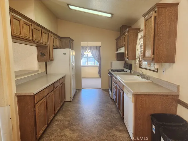 a kitchen with a sink refrigerator and cabinets