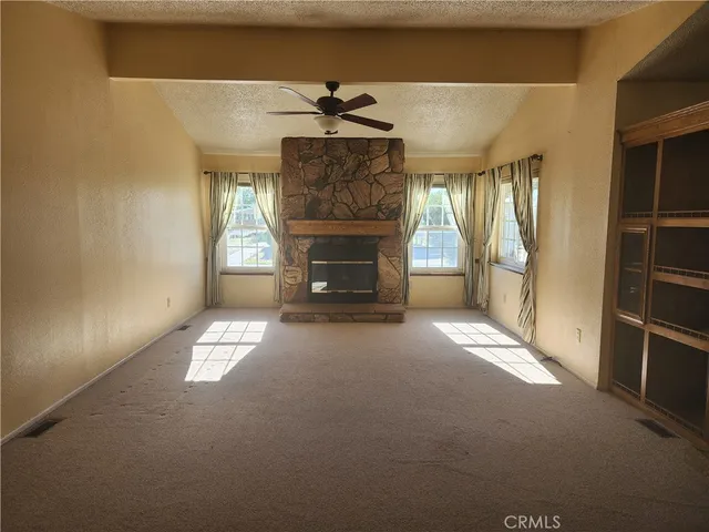 a view of empty room with fireplace and windows