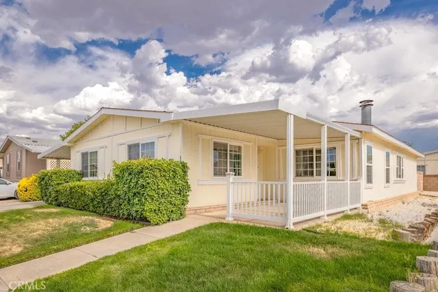 a view of a house with a big yard and large trees
