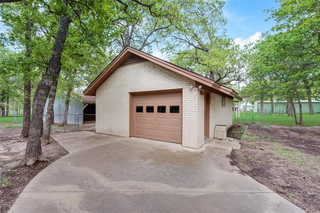 460 West J E Woody Road Springtown, TX 76082 - Photo 18 of 22 a view of a house with a yard and large tree