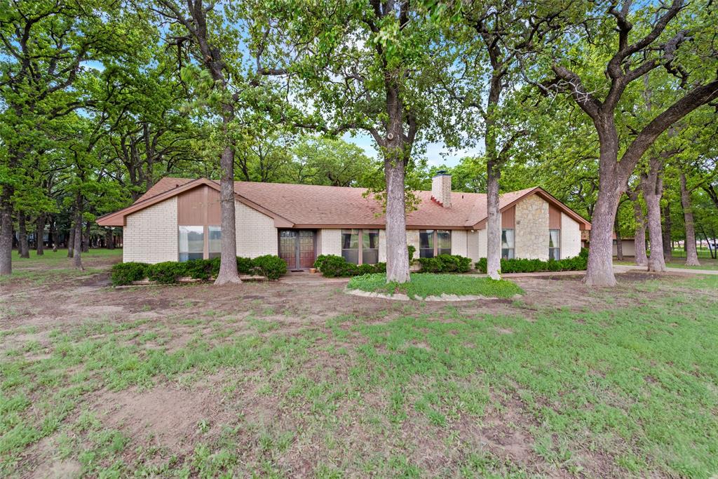 460 West J E Woody Road Springtown, TX 76082 - Photo 2 of 19 a front view of a house with a garden and deck