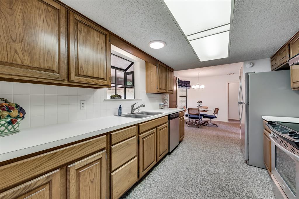 460 West J E Woody Road Springtown, TX 76082 - Photo 9 of 22 a kitchen with sink cabinets and stainless steel appliances