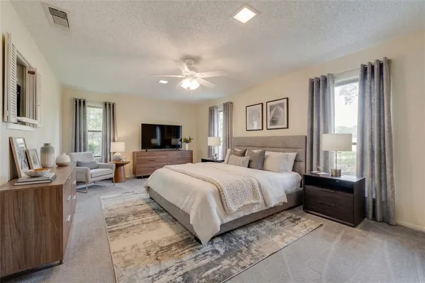 a spacious bedroom with a large bed and a flat screen tv