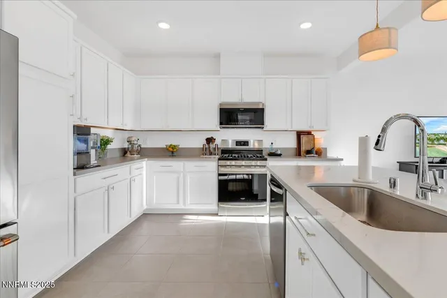 a kitchen with granite countertop a sink and white appliances