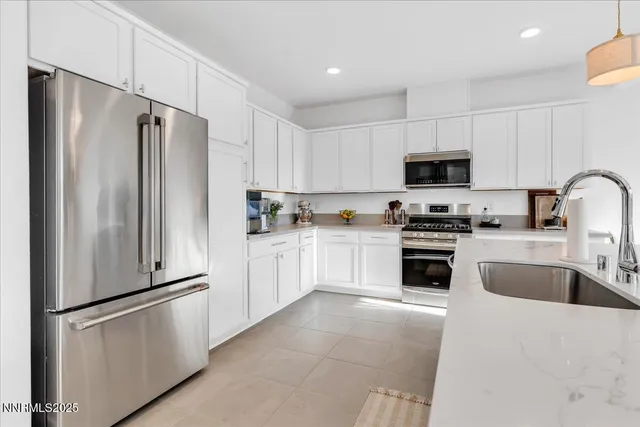 a kitchen with white cabinets and stainless steel appliances