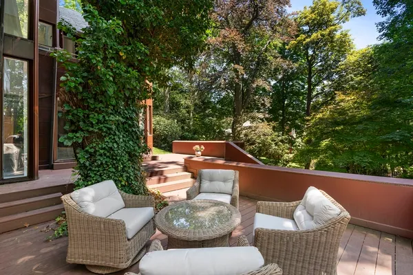 a view of a patio with table and chairs potted plants with large tree