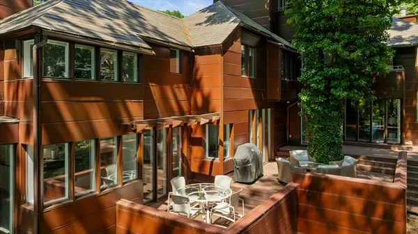 a front view of a house with a tree