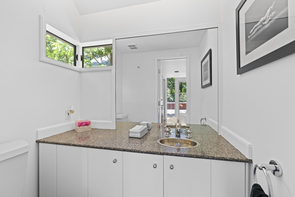 331 Heath Street Brookline, MA 02467 - Photo 7 of 31 a bathroom with a granite countertop sink and a mirror
