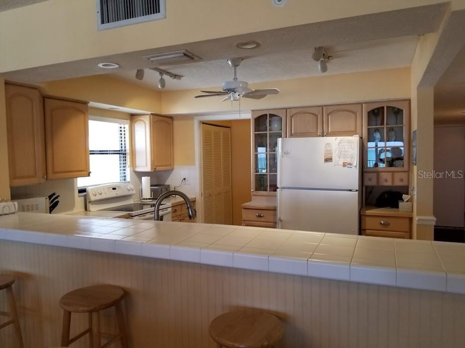 13650 Gulf Boulevard, Unit 304 Madeira Beach, FL 33708 - Photo 18 of 63 a kitchen with refrigerator and windows