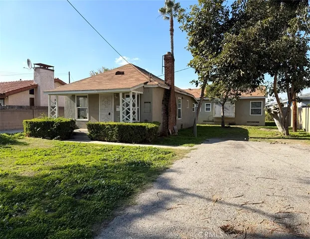 a front view of a house with a yard and potted plants